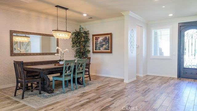 dining room featuring visible vents, baseboards, wood finished floors, and crown molding