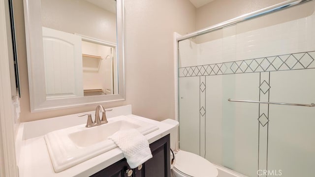 bathroom featuring a stall shower, toilet, and vanity