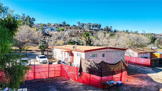 back of property featuring stucco siding and fence