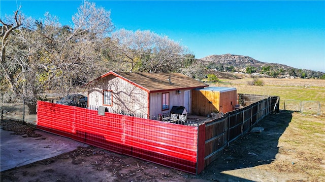 view of outbuilding with a mountain view and fence