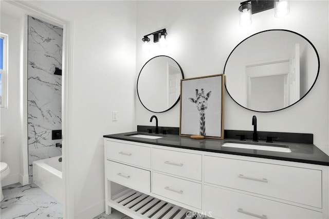 bathroom featuring double vanity, toilet, marble finish floor, and a sink