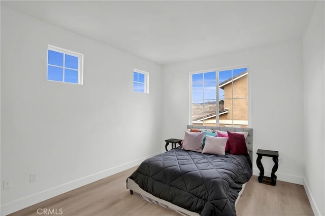 bedroom featuring wood finished floors and baseboards