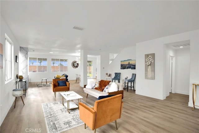 living room featuring visible vents, baseboards, and light wood-style floors