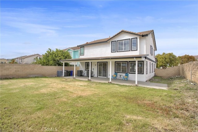 rear view of property featuring a patio, a yard, a fenced backyard, and stucco siding