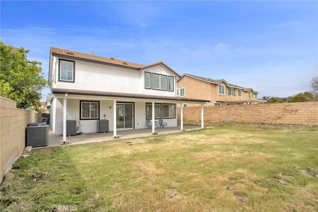 back of house featuring a patio area, a lawn, central AC, and stucco siding