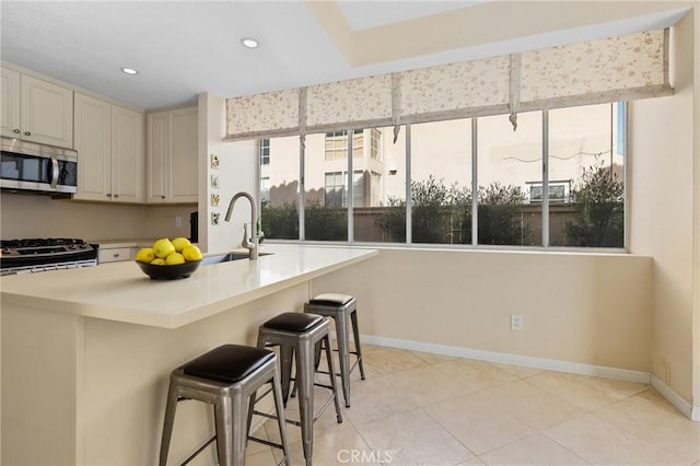 kitchen featuring a sink, a breakfast bar area, a healthy amount of sunlight, and stainless steel appliances