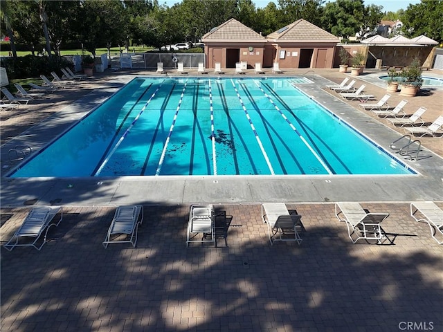 pool with a patio and fence