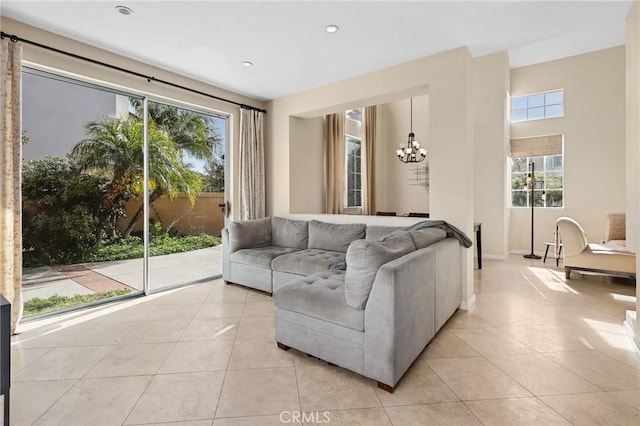 living area with light tile patterned floors, baseboards, a notable chandelier, and recessed lighting