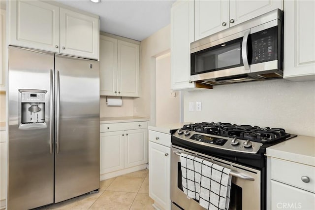 kitchen featuring light tile patterned floors, white cabinets, stainless steel appliances, and light countertops