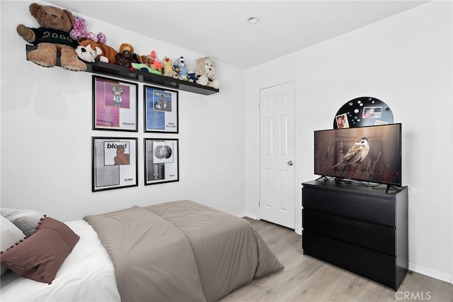 bedroom featuring baseboards and wood finished floors