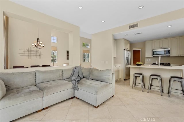 living area with a notable chandelier, light tile patterned floors, recessed lighting, and visible vents