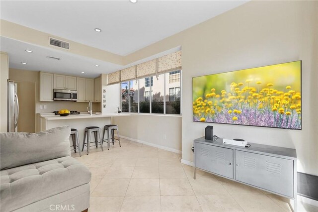 living area featuring recessed lighting, light tile patterned floors, baseboards, and visible vents