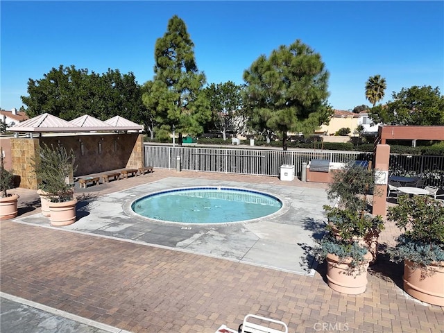 view of pool featuring a patio area, area for grilling, and fence