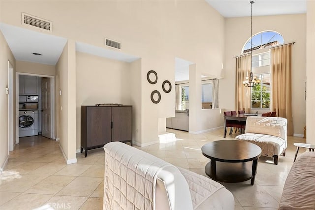 living room featuring light tile patterned floors, visible vents, and washer / dryer