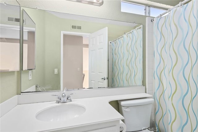 full bathroom featuring vanity, toilet, and visible vents