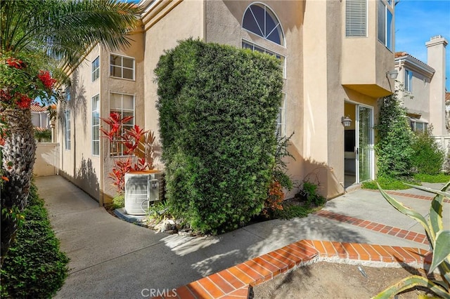 exterior space with stucco siding and central air condition unit