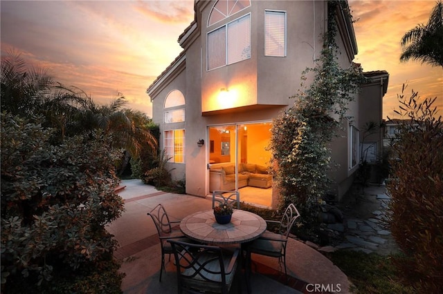 back of house featuring stucco siding and a patio