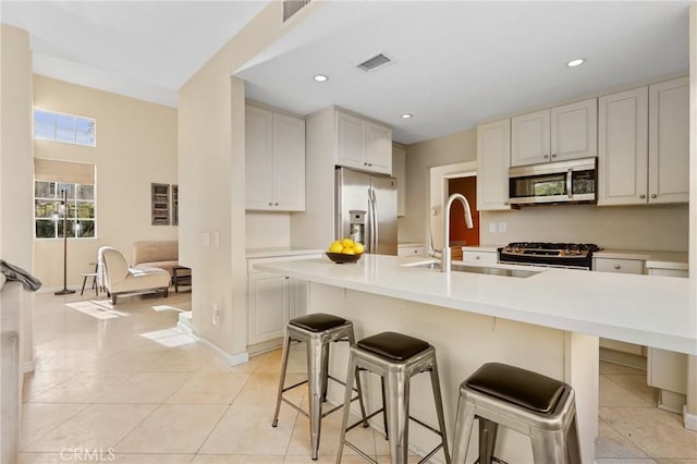 kitchen featuring a sink, light tile patterned flooring, visible vents, and stainless steel appliances