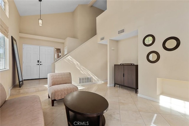 entrance foyer with light tile patterned floors, visible vents, and high vaulted ceiling