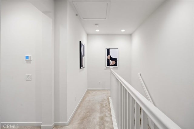 hall featuring recessed lighting, an upstairs landing, baseboards, and light carpet