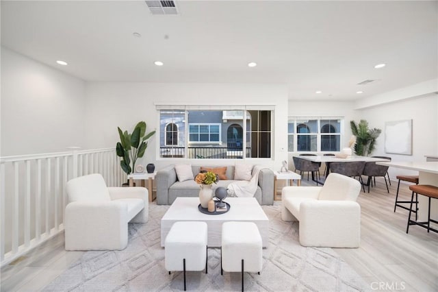 living area featuring recessed lighting, visible vents, and light wood finished floors