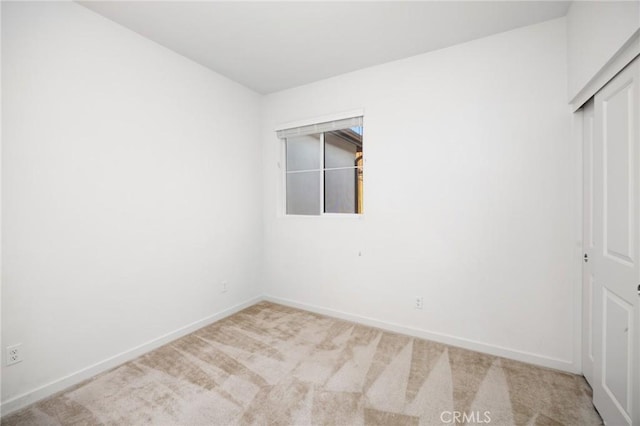 unfurnished room with carpet flooring and baseboards