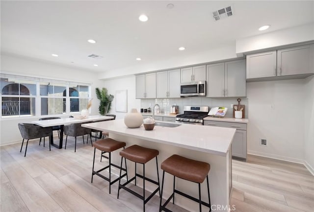 kitchen featuring a sink, stainless steel appliances, and gray cabinets