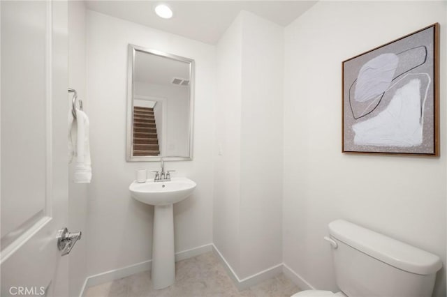 bathroom featuring tile patterned flooring, visible vents, toilet, and baseboards