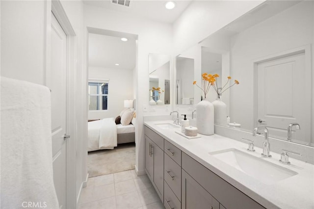 bathroom featuring double vanity, visible vents, connected bathroom, and a sink