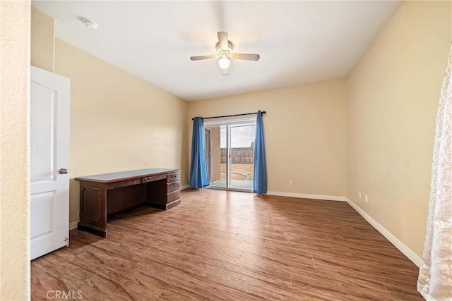 spare room featuring ceiling fan, baseboards, and wood finished floors