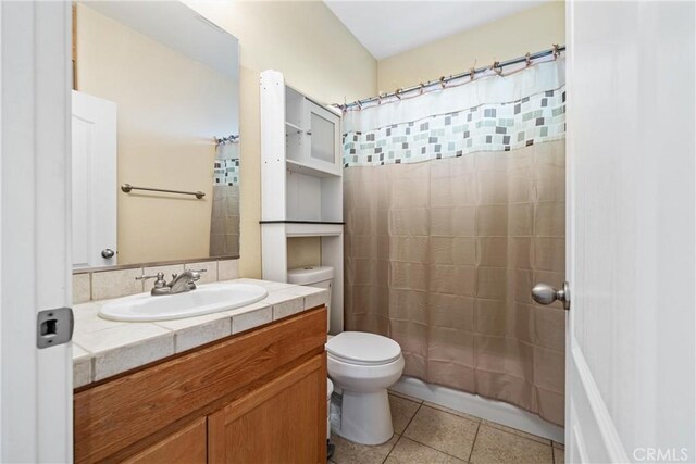 bathroom with vanity, tile patterned floors, toilet, and a shower with curtain