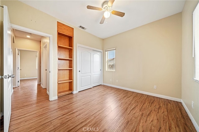 unfurnished bedroom featuring visible vents, a ceiling fan, a closet, light wood-style floors, and baseboards