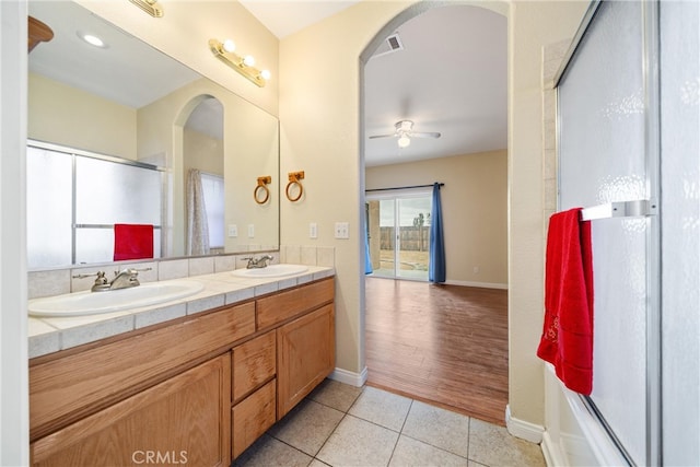 full bath with a sink, visible vents, double vanity, and tile patterned floors