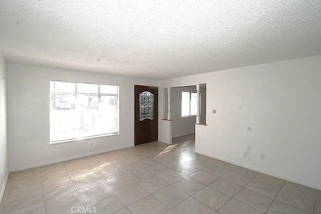 1111 Taos Dr, Barstow, CA 92311 - foyer entrance featuring a textured ceiling, light tile patterned flooring, and baseboards