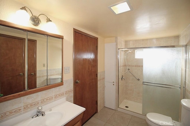 1111 Taos Dr, Barstow, CA 92311 - full bathroom featuring toilet, a shower stall, vanity, tile walls, and tile patterned floors