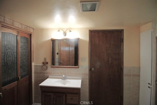 1111 Taos Dr, Barstow, CA 92311 - bathroom with tile walls, vanity, and a wainscoted wall