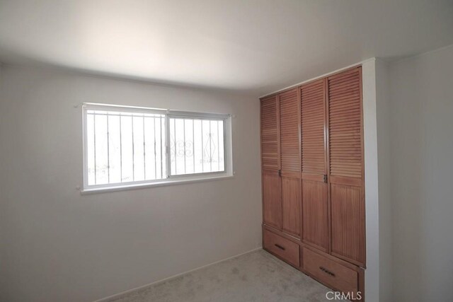 1111 Taos Dr, Barstow, CA 92311 - unfurnished bedroom featuring multiple windows, a closet, and light carpet