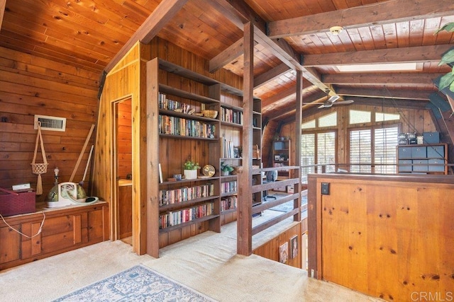 interior space with wooden ceiling, carpet flooring, wood walls, and lofted ceiling with skylight