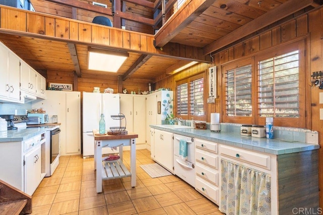 kitchen featuring a sink, white appliances, wooden ceiling, and tile counters