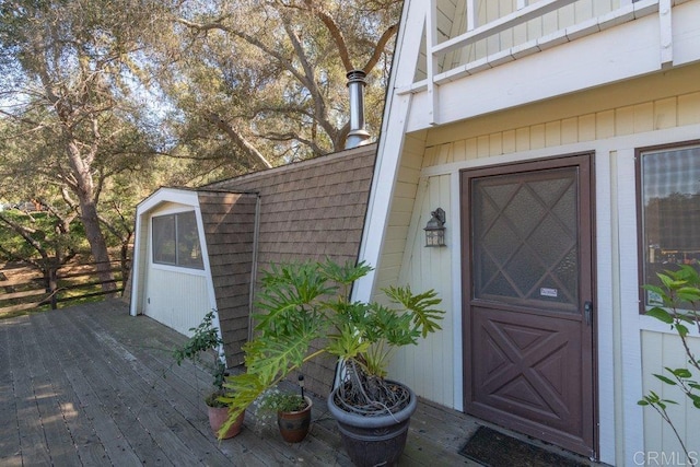 view of exterior entry with a shingled roof