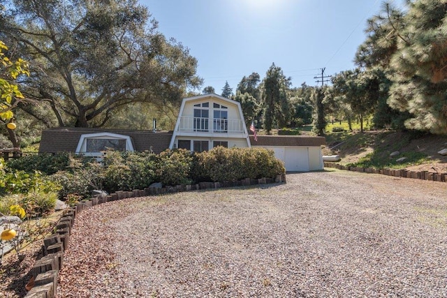 a-frame home with a gambrel roof and driveway