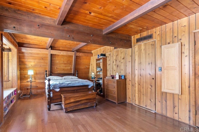 bedroom featuring beamed ceiling, wooden walls, wood ceiling, and wood finished floors