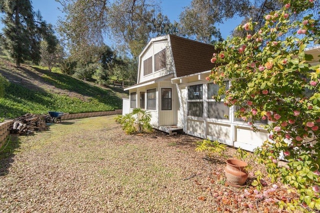 view of property exterior with a lawn and a shingled roof