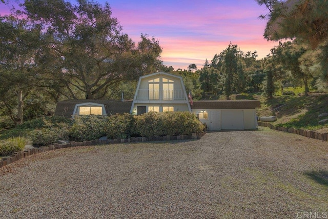 a-frame style home featuring an outbuilding, a storage unit, and gravel driveway