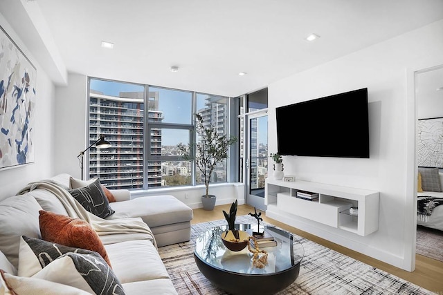 living area featuring baseboards, light wood-style flooring, and recessed lighting