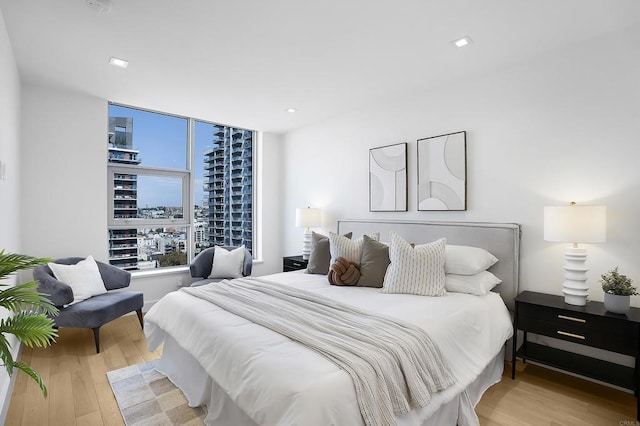bedroom with recessed lighting and wood finished floors