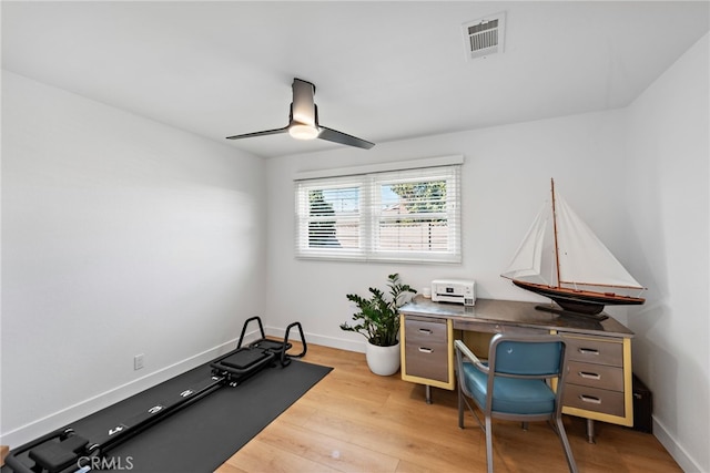 home office featuring a ceiling fan, light wood-style flooring, baseboards, and visible vents