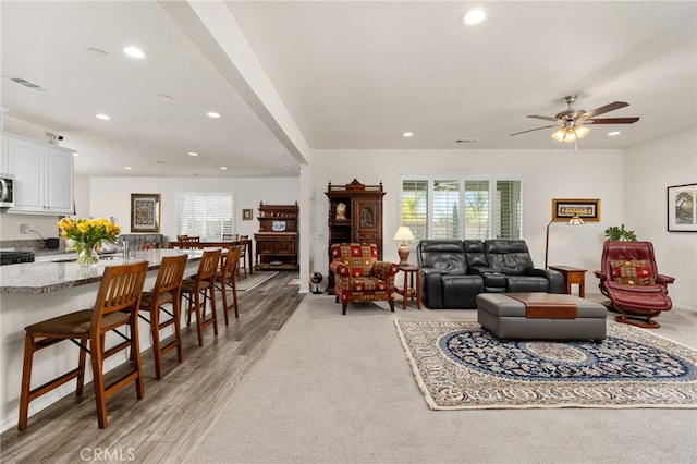 living room with visible vents, recessed lighting, light wood-style flooring, and a ceiling fan