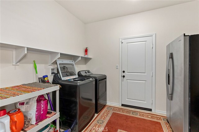 clothes washing area featuring laundry area, baseboards, and independent washer and dryer