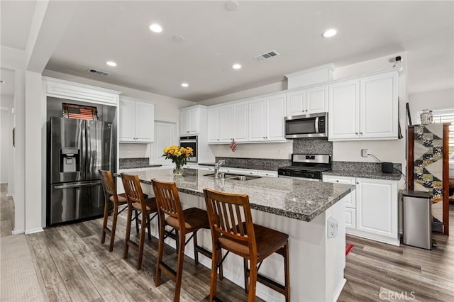 kitchen featuring a sink, visible vents, appliances with stainless steel finishes, and light wood finished floors